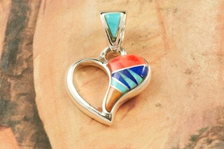 Genuine Turquoise, Spiny Oyster Shell and Blue Lapis inlaid between ribbons of Sterling Silver. Fire and Ice Lab Opal Accents. Stunning Pendant with precision inlay on the Bale and Pendant. Free 18" Sterling Silver Chain with Purchase of Pendant. Designed by Navajo Artist Calvin Begay. Signed.